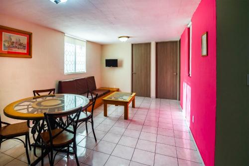 a room with a table and chairs and a pink door at Suites Navata in Guadalajara