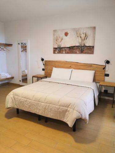 a bedroom with a large bed with a wooden headboard at B&B Ca' Restom in Reggio Emilia