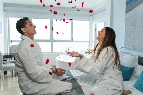 a man and woman sitting on a bed in a room at Hotel Villa del Mar in Benidorm