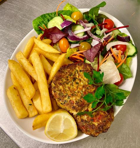 a plate of food with a steak and a salad and french fries at Mariners Hotel in Seaton