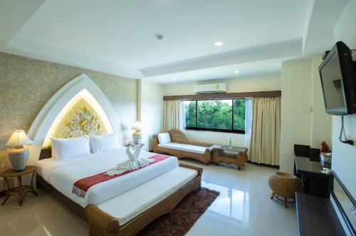 a hotel room with a bed and a television at Phanomrungpuri Hotel Buriram in Nang Rong