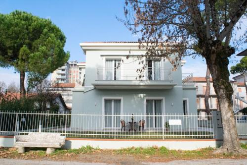 a white house with a fence and a bench at Suite Apartments in Cervia