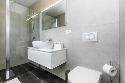 a white bathroom with a sink and a mirror at Villa LEA MAGDALENA in Malinska