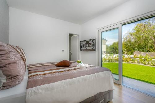 a bedroom with a bed and a large window at Villa LEA MAGDALENA in Malinska