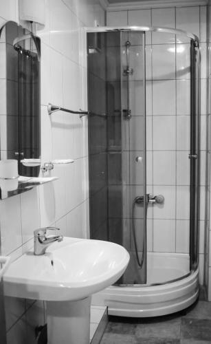 a bathroom with a glass shower and a sink at Tourist Chernivtsi in Chernivtsi