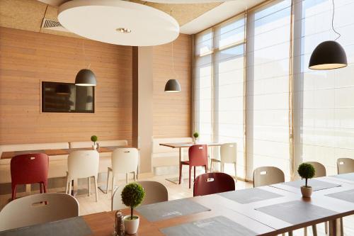a restaurant with tables and chairs and large windows at Campanile Bydgoszcz in Bydgoszcz