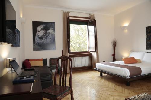 a bedroom with a bed and a desk with a laptop at Residenza Delle Arti in Rome