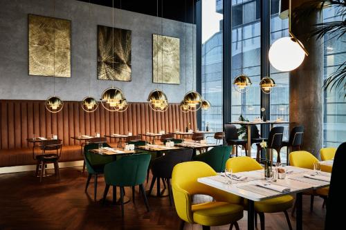 a restaurant with tables and chairs and windows at Crowne Plaza - Warsaw - The HUB by IHG in Warsaw
