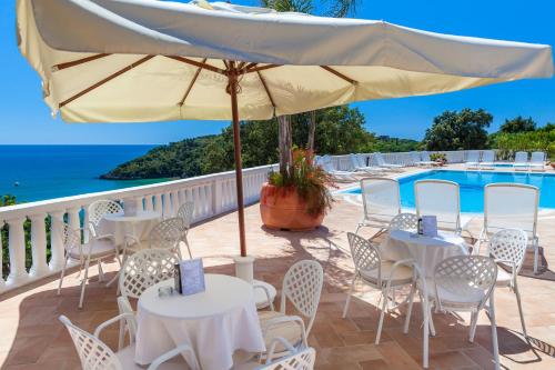 a patio with tables and chairs and a pool at Grand Hotel Le Rocce in Gaeta