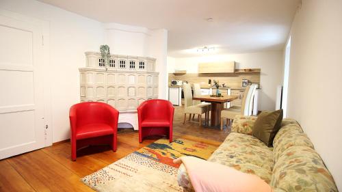a living room with a couch and two red chairs at Ferienwohnung am Wasserschloss 1-3 in Ochsenfurt