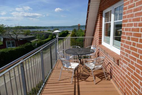 a patio with a table and chairs on a balcony at Haus am Deich Feriendomizil mit Balkon in Baabe