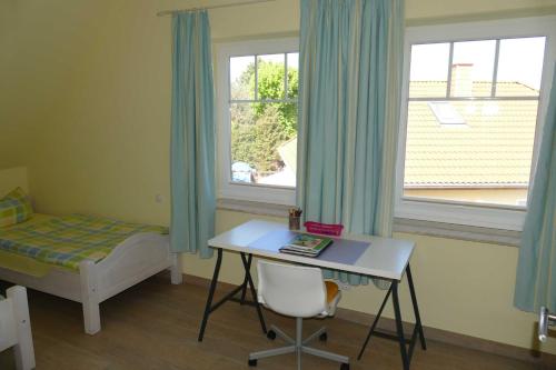 a bedroom with a desk and a bed and a window at Haus am Deich Feriendomizil mit Balkon in Baabe