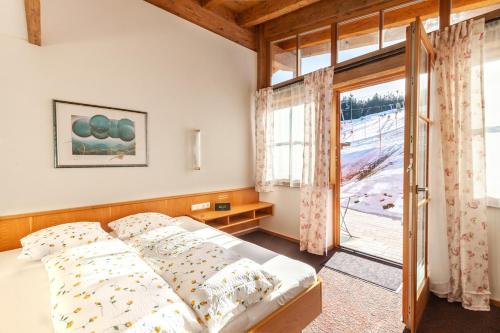 a bedroom with a bed and a large window at Alpengasthof Götschenalm in Bischofswiesen