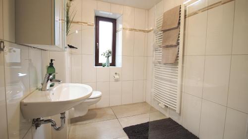 a white bathroom with a sink and a toilet at Ferienwohnung am Wasserschloss 1-3 in Ochsenfurt