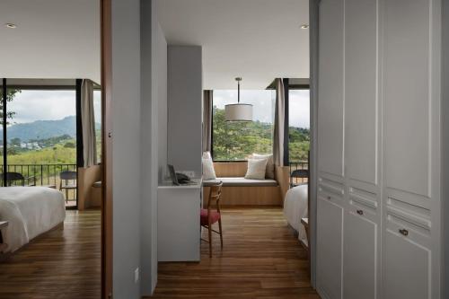 a bedroom with a view of a living room with a couch at Sirinati Khao Kho in Khao Kho