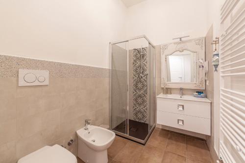 a bathroom with a toilet and a sink and a mirror at Prima dell'Elba Family Apartments in Piombino