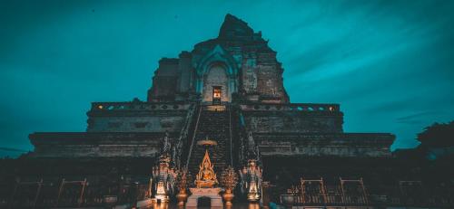 a large building with lights on it at night at Parasol Inn Chiang Mai Old City in Chiang Mai