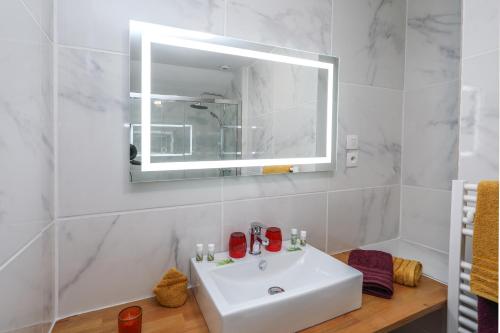 ein weißes Badezimmer mit einem Waschbecken und einem Spiegel in der Unterkunft Style Industriel Aux Bords de la Loire in Blois
