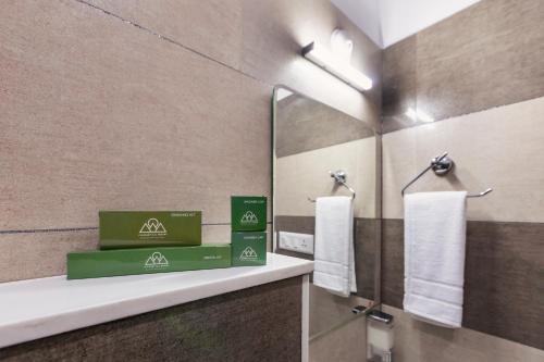 a bathroom with two boxes on a counter and a mirror at Pleasant Hill Resort in Munnar