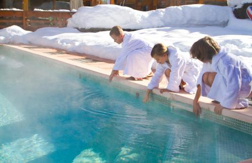 a group of people in white suits standing next to a swimming pool at Hotel Eterlou in Méribel