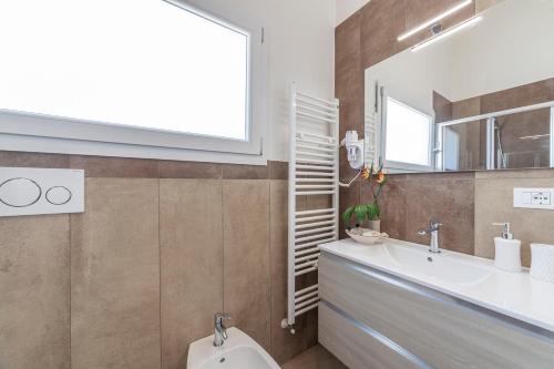 a bathroom with a sink and a toilet and a window at Prima dell'Elba Family Apartments in Piombino