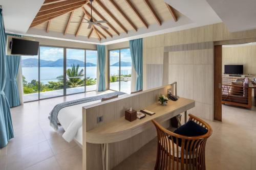 a bedroom with a bed and a view of the ocean at Kalima Resort and Spa in Patong Beach