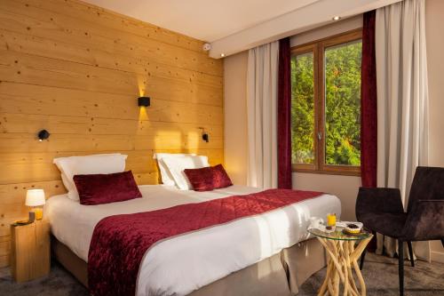 a hotel room with two beds and a window at Hôtel Les Grillons in Talloires