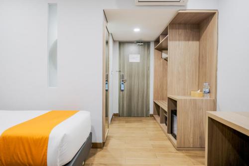 מיטה או מיטות בחדר ב-Sans Hotel Puri Indah Jakarta