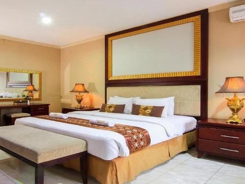 een slaapkamer met een groot bed met een groot frame bij Hotel Signature Mandala Kencana in Cianjur