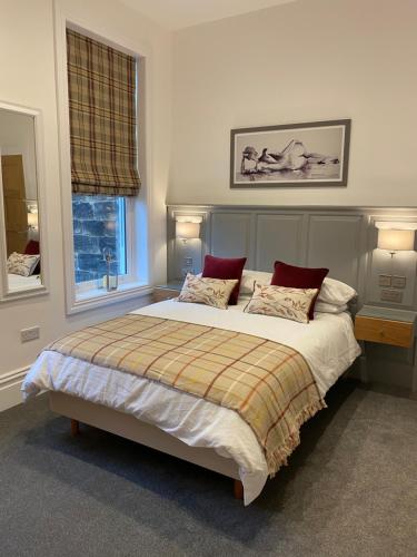 ein Schlafzimmer mit einem großen Bett mit zwei Kissen in der Unterkunft Wells House luxury 2 bedroom apartment in Harrogate