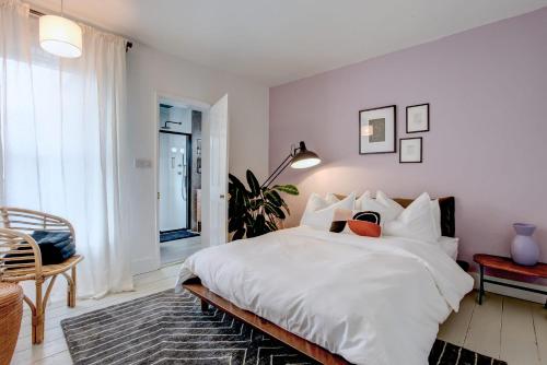 a white bedroom with a large bed and a window at Ideal for contractors discounted longer stays Designer city centre home with free parking in Norwich