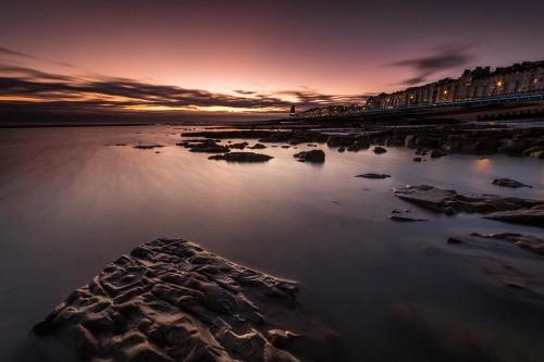 a sunset over a body of water with rocks at NORTHRISE RETREAT in Hastings