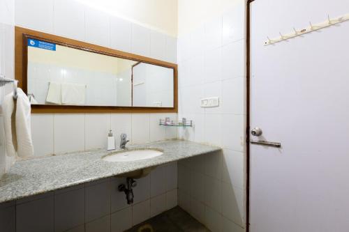 a bathroom with a sink and a mirror at KSTDC Hotel Mayura Sangama Mekedatu in Mulhalli