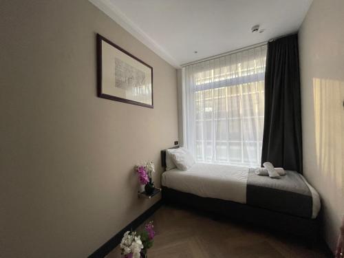 a bedroom with a bed and a window with flowers at H3 Hotel Rotterdam City Center in Rotterdam