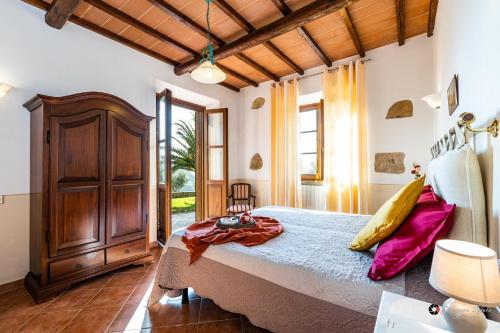 Un dormitorio con una cama y un armario de madera. en Bio Fattoria Il Poggiarello, en Volterra