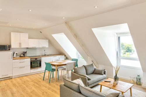 une cuisine et un salon avec une table et des chaises dans l'établissement Résidence du Phare - 4 appartements - 2 chambres - Vue mer ou Terrasse, à Combrit