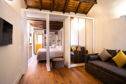 Smeraldo Townhouse في روما: غرفة معيشة مع سرير وأريكة