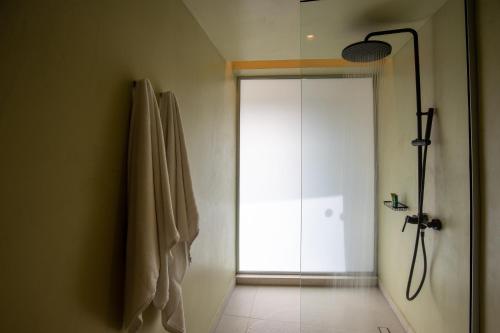 a bathroom with a shower and a glass door at Kouros Exclusive Hotel & Suites - Adults Only in Faliraki
