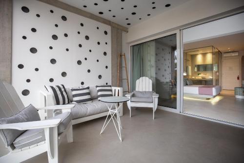 a living room with a couch and a table at Kouros Exclusive Hotel & Suites - Adults Only in Faliraki