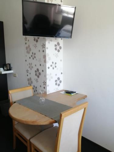 a table and chairs with a television on the wall at B&B V.K. PGmbH in Saint-Vith