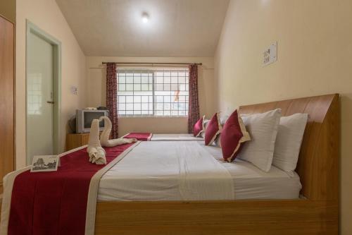 a bedroom with a large bed with stuffed animals on it at KSTDC Hotel Mayura TalaKaveri, Bhagamandala in Madikeri