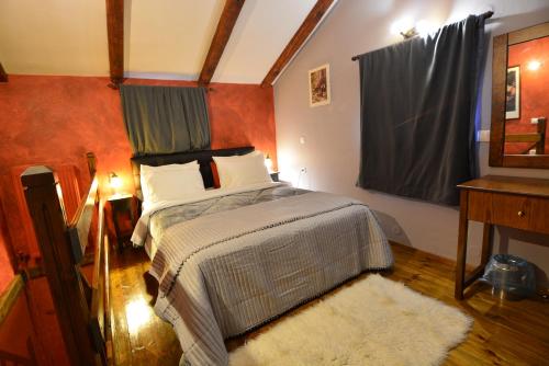 a bedroom with a bed and a table and a window at Georgio's V Chalet Kalavrita in Kalavrita