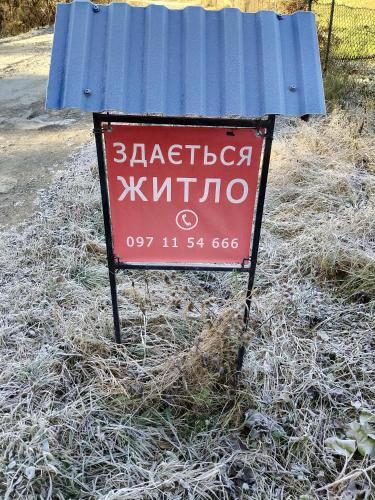 a sign that is sitting in the grass at "Відпочинок в Карпатах" in Izki