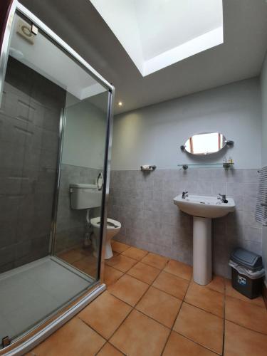 W łazience znajduje się prysznic, umywalka i toaleta. w obiekcie Low Farm Cottages w mieście Woodbridge
