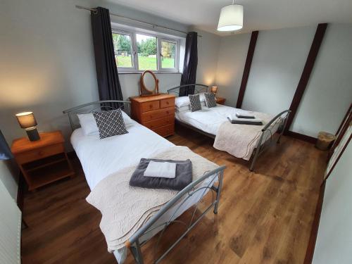 a room with two beds and a mirror at Low Farm Cottages in Woodbridge