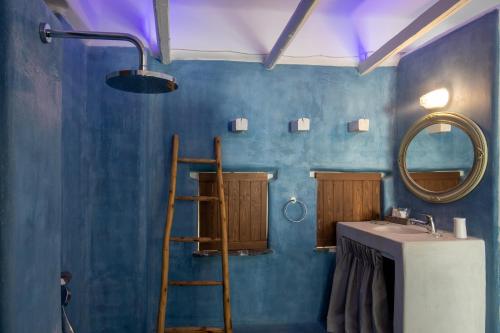 a bathroom with a sink and a mirror at Kouros Exclusive Hotel & Suites - Adults Only in Faliraki