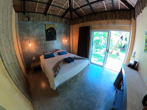 a bedroom with a bed and a large window at Asian Secret Resort in Lamai