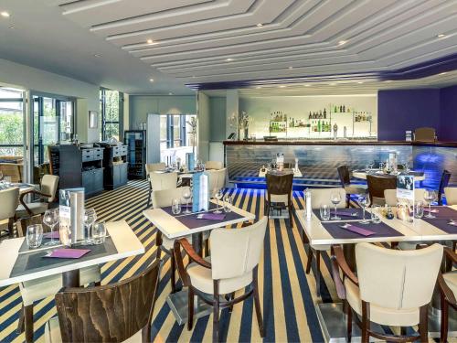 een restaurant met tafels en stoelen en een bar bij Mercure Paris Orly Rungis Aéroport in Rungis