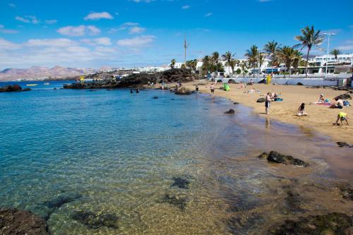 a beach scene with people on the beach at Apartamentos Panorama Adults Only in Puerto del Carmen