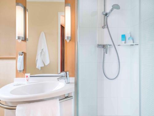 une salle de bain avec un lavabo et une douche dans l'établissement ibis Nantes Centre Tour Bretagne, à Nantes